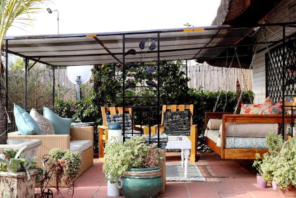Covered patio with swing bench and garden seating